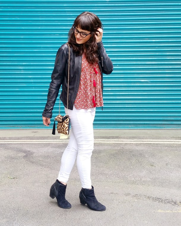 Call Me Katie - wearing white jeans, black leather jacket, heeled boots and red pompom tunic for weekend look 1